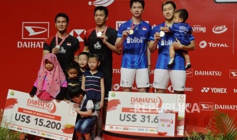 Ganda putra Indonesia Kevin Sanjaya Sukamuljo dan Marcus Fernaldi Gideon memegang medali emas seusai mengalahkan lawan senegara Hendra Setiawan dan Mohammad Ahsan dalam pertandingan babak final Daihatsu Indonesia Masters 2020 di Istora Senayan, Jakarta, Ahad (19/1).