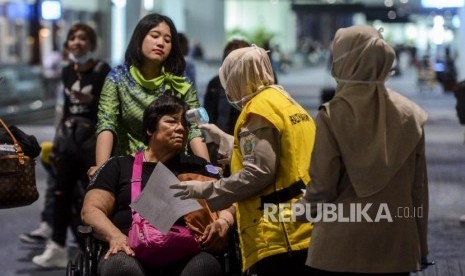 Bandara Sultan Mahmud Badaruddin II Palembang terus memasang alat pemindai suhu tubuh (thermal scanner)terkait antisipasi virus korona (Foto: petugas memeriksa penumpang bandara dengan thermal scanner)