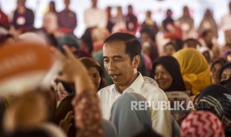 Presiden Joko Widodo menyapa sejumlah warga Keluarga Penerima Manfaat (KPM) saat acara Penyerahan Program Keluarga Harapan Tahap I Tahun 2020 di Lapangan Rajawali, Kota Cimahi, Rabu (29/1).