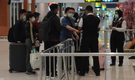 Sejumlah wisatawan dari negara China antre saat memasuki pintu terminal keberangkatan Bandara Adi Soemarmo, Boyolali, Jawa Tengah, Rabu (29/1). Kementerian Perhubungan (Kemenhub) memastikan Bandara Adi Soemarmo Solo kembali dibuka. 