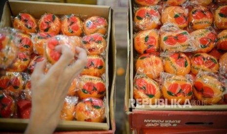 Pembeli memilah buah impor dikawasan Pasar Induk Kramat Jati, Jakarta Timur, Selasa (4/2). Asosiasi Eksportir Importir Buah dan Sayuran Indonesia (Aseibsindo) mengeluhkan lambatnya rekomendasi dan perizinan impor komoditas buah dan sayur dari pemerintah. Ketua Aseibsindo menuturkan, hambatan itu akan berdampak pada kenaikan harga lantaran nilai tukar rupiah terlanjur melemah terhadap dolar AS.