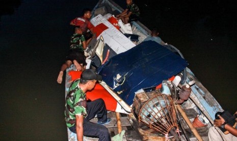 Sejumlah prajurit membawa bagian pesawat latih yang mendarat darurat menggunakan perahu di kawasan Kedungpeluk, Candi, Sidoarjo, Jawa Timur, Selasa (4/2/2020).