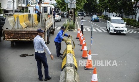 Petugas Dinas Perhubungan (Dishub) memasang pembatas beton 