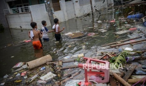 BPBD Tangerang Evakuasi Korban Banjir di Periuk. Sejumlah anak berjalan melewati genangan air saat banjir di kawasan Perumahan Periuk Damai, Kota Tangerang, Banten. Foto ilustrasi.