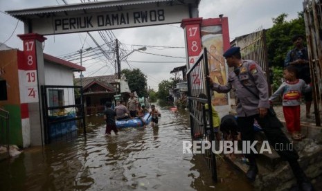 Sejumlah warga menaiki perahu karet saat banjir di kawasan Perumahan Periuk Damai, Kota Tangerang, Banten, Kamis (6/2).