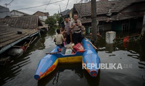 Sejumlah warga bersama Petugas Kepolisian menaiki perahu karet saat banjir di kawasan Perumahan Periuk Damai, Kota Tangerang, Banten, Kamis (6/2).