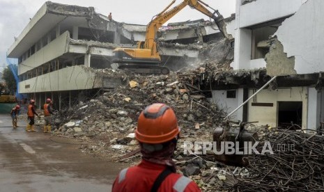 Pekerja membongkar gedung menggunakan alat berat di lokasi proyek revitalisasi kawasan Taman Ismail Marzuki (TIM) di Jakarta, Jumat (7/2).