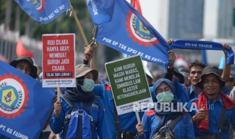 Sejumlah massa buruh melakukan aksi unjuk rasa di depan Gedung DPR RI, Jakarta, Rabu (12/2).