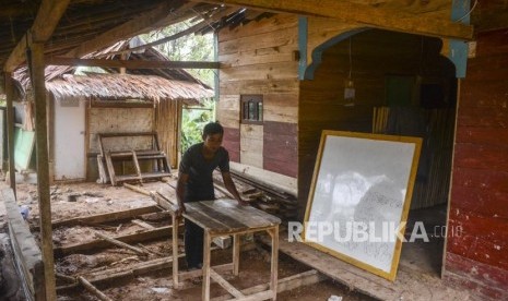 Seorang warga mengangkut meja di pondok pesantren yang hancur akibat bencana alam di Kampung Ciparempeng, Desa Cileuksa, Sukajaya, Kabupaten Bogor, Jawa Barat, Kamis (13/2).