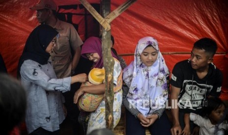 Bupati Lebak Iti Octavia Jayabaya (kiri) berbincang dengan warga di hunian sementara (huntara) di Kampung Cogobang, Desa Banjarsari, Kecamatan Lebak Gedong, Kabupaten Lebak, Banten, Kamis (13/2).