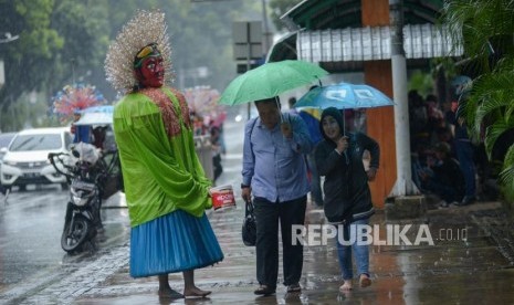 Pengamen ondel-ondel berkeliling. Aparat Satpol PP Kota Depok akan menindak tegas pengelola ondel-ondel yang melibatkan anak di bawah umur untuk mengamen di jalan.