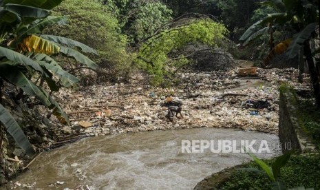 Seorang pemulung mencari sampah yang berada di aliran Sungai Kalibaru, Cibinong, Bogor, Jawa Barat, Senin (17/2).