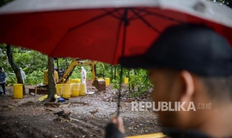 Petugas Kesatuan KBR (Kimia Biologi Radioaktif) Gegana Mabes Polri bersama petugas PTKMR (Pusat Teknologi Keselamatan Meteorologi Radiasi) mengukur paparan radiasi di area terpapar di Perumahan Batan Indah, Kota Tangerang Selatan, Banten, Senin (17/2).