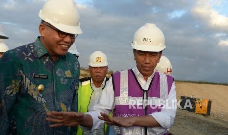 Presiden Joko Widodo (kanan) berbincang dengan Plt Gubernur Aceh Nova Iriansyah (kiri) saat meninjau perkembangan pembangunan Seksi IV jalan tol di Desa Indra Puri, Kabupaten Aceh Besar, Aceh, Jumat  (21/2/2020). (ilustrasi)