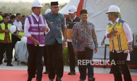 Presiden Joko Widodo (kiri) didampingi Plt Gubernur Aceh, Nova Iriansyah (kedua kiri) berjalan saat meninjau perkembangan pembangunan Seksi IV jalan tol di Desa Indra Puri, Kabupaten Aceh Besar, Aceh, Jumat ( 21/2/2020).(AMPELSA/ANTARA FOTO)