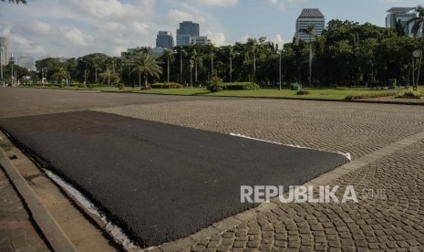 Kondisi lapisan aspal di area percobaan pengasopalan lintasan Formula E non permanen di kawasan Monumen Nasional, Jakarta, Ahad (23/2).(Republika/Thoudy Badai)