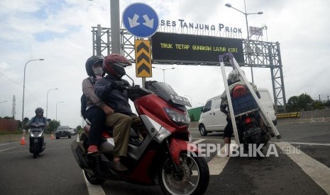 Pengendara sepeda motor masuk ke Jalan Tol Akses Tanjung Priok untuk menghindari banjir di Jakarta Utara, Senin (24/2).