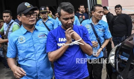 Petugas Badan Narkotika Nasional menggiring tersangka saat penggeledahan rumah produksi narkoba di Jalan Cingised, Kelurahan Cisaranten Endah, Kecamatan Arcamanik, Kota Bandung, Senin (24/2).