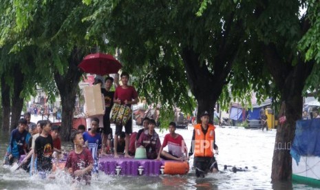 Warga bersama-sama mendorong pelampung rakitan untuk mengangkut motor dan masyarakat agar terhindar dari banjir di jalan Sunter Kemayoran Jakarta, Selasa (25/2).