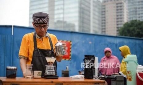 Calon wakil gubernur DKI Nurmansjah Lubis berdagang kopi di area CFD Jalan Jenderal Sudirman, Jakarta, Ahad (2/3).