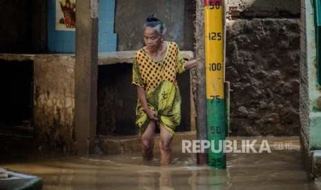 Warga berjalan di area yang terendam banjir di kawasan Kebon Pala, Jatinegara, Jakarta, Senin (2/3).(Republika/Thoudy Badai)