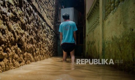 Warga membersihkan rumahnya yang terendam banjir di kawasan Kebon Pala, ilustrasi