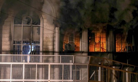 Gedung Kedubes Arab Saudi yang terbakar saat aksi unjuk rasa di Tehran, Iran, Sabtu (2/1).