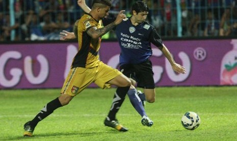 Pesepakbola Arema Cronus, Esteban Viscara (kanan) berusaha melewati pesepakbola Mitra Kukar, Arthur Do Santos (kiri) dalam semifinal Piala Jenderal Sudirman leg kedua di Stadion Kanjuruhan, Malang, Ahad (17/1). (Antara/Ari Bowo Sucipto)