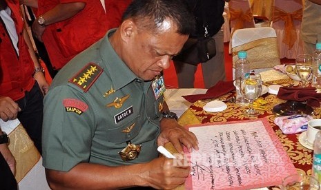  Panglima TNI Jenderal Gatot Nurmantyo menulis pesan lingkungan usai apel siaga di Sungai Baung, Kabupaten Ogan Komering Ilir (OKI) Sumatera Selatan (Sumsel), Kamis (24/3).  (Republika/Maspril Aries)