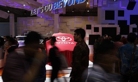 Pengunjung melintasi stan Toyota Sienta pada Indonesian International Motor Show (IIMS) 2016, Jakarta.