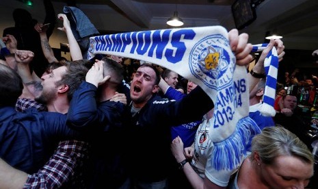 Suporter Leicester City merayakan keberhasilan tim kesayangan mereka yang berhasil meraih gelar Liga Primer Inggris.  (Reuters/Eddie Keogh)