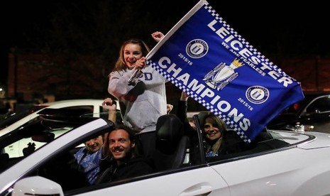 Suporter Leicester City merayakan keberhasilan tim kesayangan mereka yang berhasil meraih gelar Liga Primer Inggris.  (Reuters/Eddie Keogh)