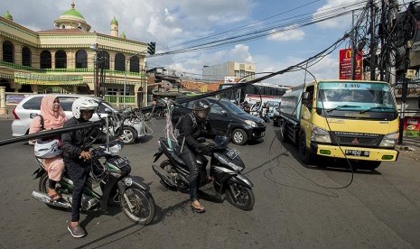  Sejumlah pengendara kendaraan bermotor berusaha melewati kabel serat optik yang melintang menutupi jalan di persimpangan lampu merah Kalibata, Jalan Dewi Sartika, Jakarta Timur, Ahad (15/5).(Antara/Widodo S. Jusuf)