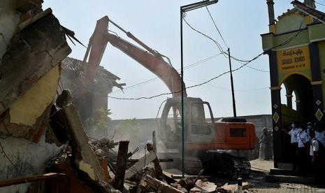 Petugas dengan bantuan alat berat merobohkan bangunan rumah saat dilakukan penggusuran puluhan rumah di kawasan Kebonharjo, Semarang, Jateng, Kamis (19/5). (Antara/R. Rekotomo)