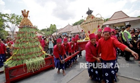  Abdi dalem Kraton Yogyakarta membawa gunungan untuk diperebutkan saat Grebeg Besar di halaman Masjid Gede, Kauman, Yogyakarta.