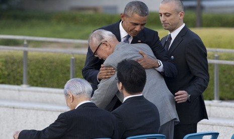   Presiden AS Barack Obama memeluk warga Jepang yang selamat dari serangan bom atom Shigeaki Mori, saat berkunjung ke Hiroshima Peace Memorial Park di Hiroshima, Jepang, Jumat (27/5). (AP/ Shuji Kajiyama)