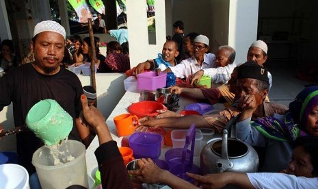 Pengurus masjid membagikan bubur pedas kepada warga di halaman Masjid Raya Al Mashun Medan, Senin (6/6). (Antara/Septianda Perdana)