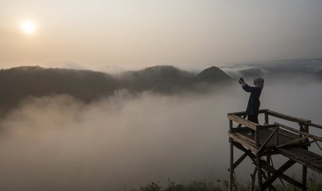 Wisatawan menikmati suasana matahari terbit di Bukit Panguk, Kediwung, Mangunan, Yogyakarta. ilustrasi (Antara/Sigid Kurniawan)