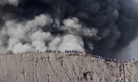 Wisatawan melihat semburan abu vulkanis di tepi kawah Gunung Bromo, Probolinggo, Jawa Timur, Selasa (12/7).  (Antara/Ari Bowo Sucipto)