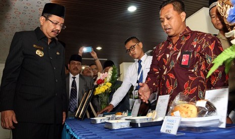 Gubernur Sumatra Utara, T Erry Nuradi (kiri) melihat paket makanan untuk jemaah calon haji selama dalam penerbangan, pada Meal Test di Asrama Haji Embarkasi Medan, Sumatra Utara, Selasa (26/7). (Antara//Irsan Mulyadi)