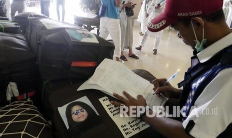 Petugas Haji memeriksa koper bawaan jamaah haji kloter BDJ 14 asal Embarkasi Banjarmasin menuju Makkah, Rabu (31/8).