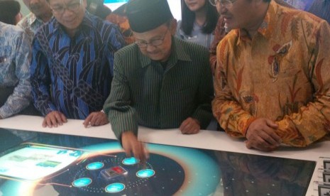 Mantan presiden BJ Habibie (tengah) sedang mencoba fasilitas smart table di outlet digital BRI di Bandara Internasional Soekarno-Hatta, Tangerang, Banten, Kamis (6/10).