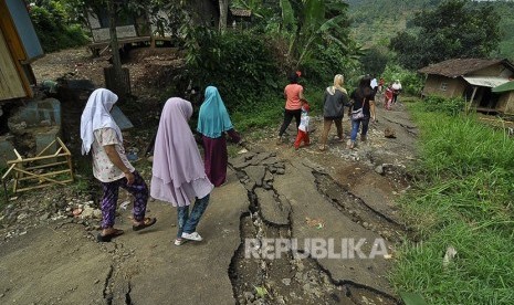  Sejumlah warga melintas di jalan yang rusak akibat pergerakan tanah (Ilustrasi)