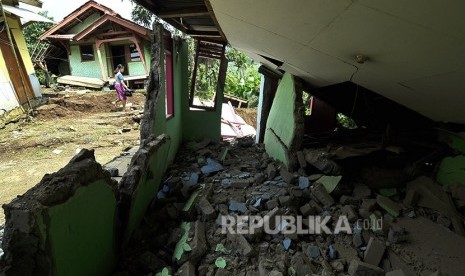 Seorang warga melintas di bagunan yang rusak akibat pergerakan tanah di Kampung Cikatomas, Sasak Gantung, Desa Citatah, Kecamatan Cipatat, Kabupaten Bandung Barat, Rabu (23/11). 