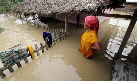 Warga berdiri di teras rumahnya yang terendam banjir di Desa Nga, Lhoksukon, Aceh Utara, Aceh, Rabu (4/1). 