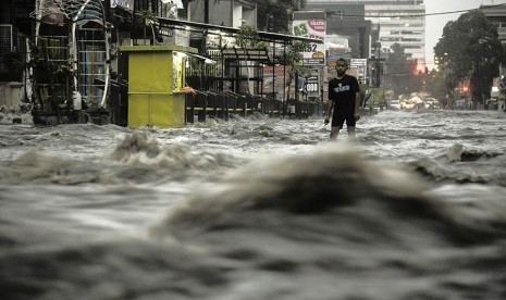 Seorang anak melintasi banjir di kawasan Pagarsih, Bandung, Jawa Barat, Senin (27/2).