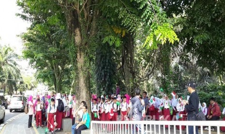 Pelajar Kota Bogor dengan bendera Indonesia-Arab Saudi disiapkan di jalur pedestrian Kebun Raya Bogor sejak pukul 10.00 WIB sambut Raja Salman, Rabu (1/3).