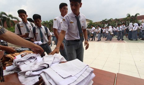 Sejumlah pelajar SMA menyumbangkan baju seragam sekolah mereka seusai pelaksanaan Ujian Nasional Berbasis Komputer (UNBK) 