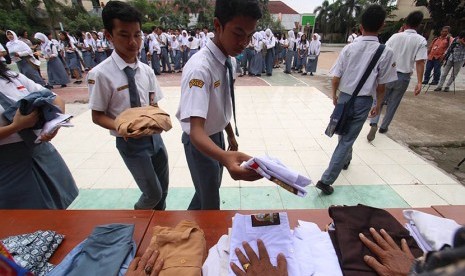 Sejumlah pelajar SMA menyumbangkan baju seragam sekolah mereka seusai pelaksanaan Ujian Nasional Berbasis Komputer (UNBK) hari terakhir di SMA Negeri 5 Medan, Sumatra Utara, Kamis (13/4).