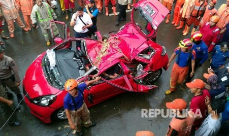 Akibat hujan deras yang disertai angin kencang dan petir sebuah  mobil tertimpa pohon, di sisi Jalan Fly Over UI, Depok, Selasa (2/5).